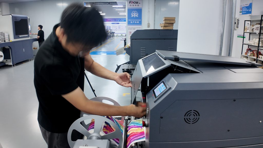FocusInc factory technician performing quality control inspection on single pass digital inkjet printer before shipment, ensuring stable performance and printing quality