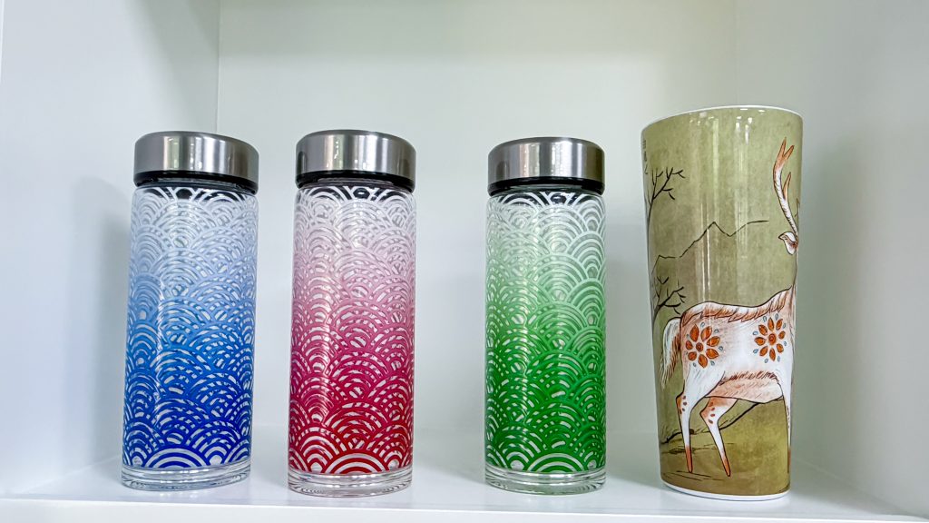 Printed glass bottle with white ink base and glossy varnish effect, made with HYDRA-360S cylinder printer